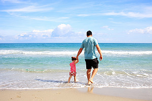 Father Daughter Walking On Beach Together