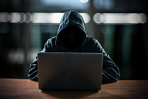 Hooded Hacker Using Laptop Computer